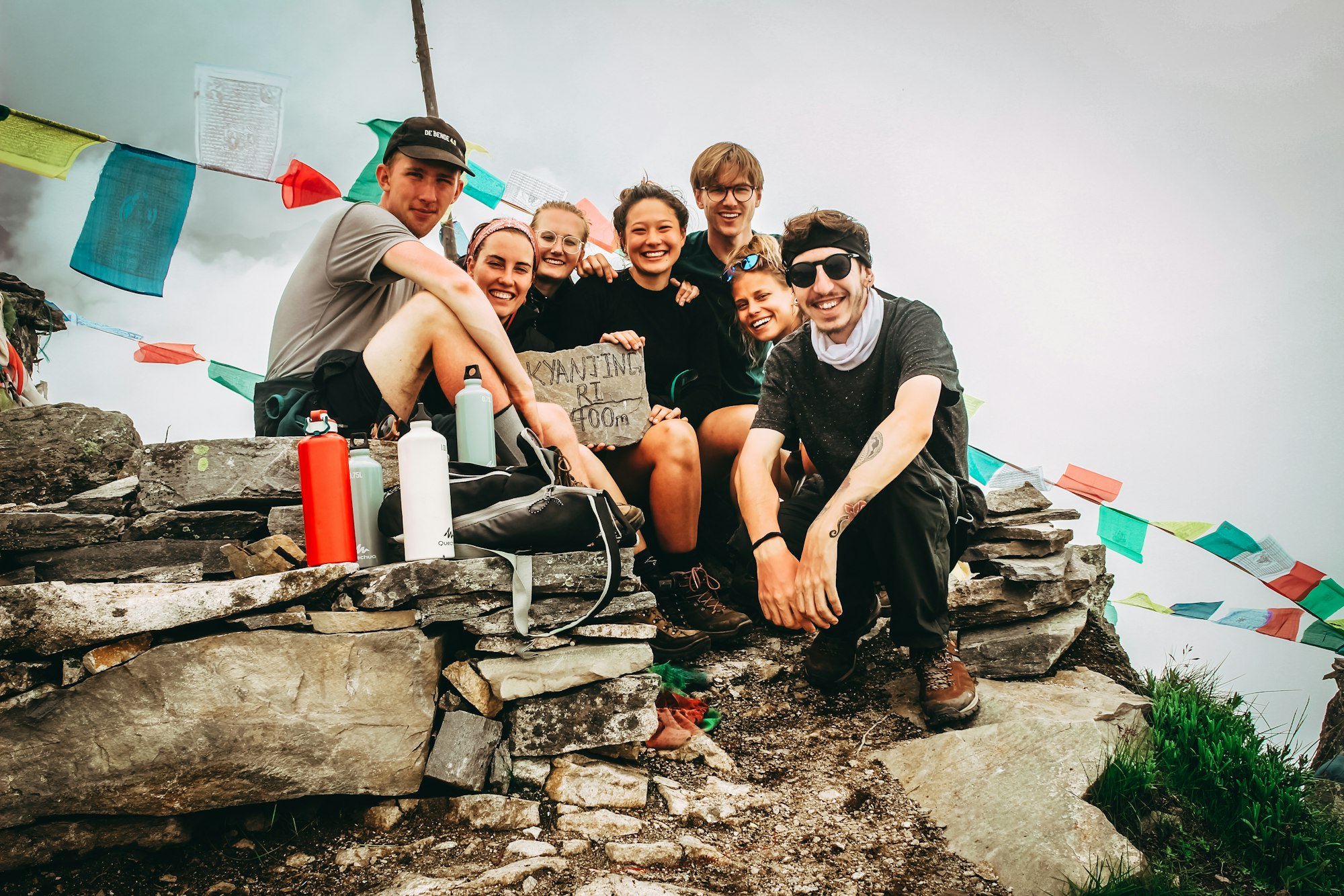 A group of friends at the top of a climb, laughing together.
